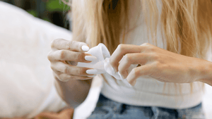 Woman cleaning out menstrual cup with cup wipe, how to clean menstrual cup